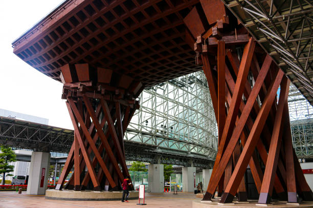 This gate, the symbol of Kanazawa Station, is made of traditional wooden architecture and is called the Tsuzumi-mon(鼓門). The design motif is a representing Noh(能楽), a traditional Japanese performing art. Many tourists come to Kanazawa, where people can enjoy the uniqueness of Japan./ Kanazawa city,  Ishikawa prefecture, Japan/ 12-05-2019