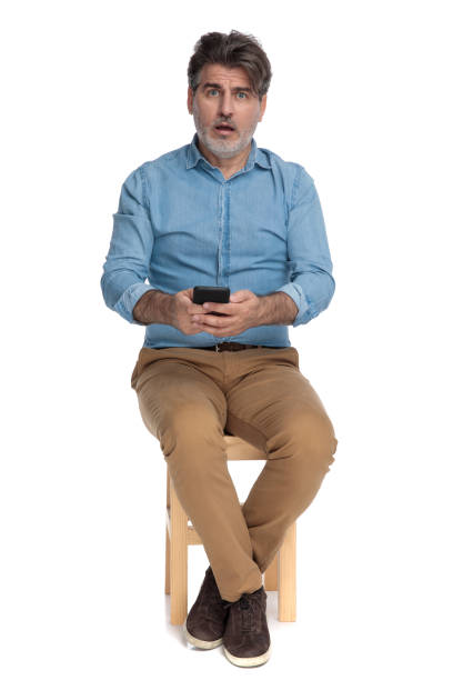 istock Amazed casual man writing on his phone and gasping 1202256051