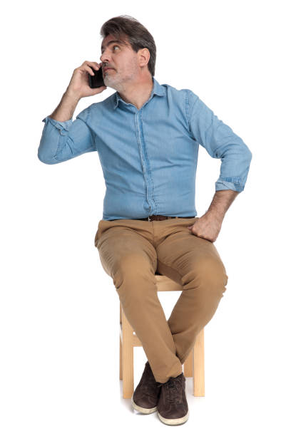 istock Busy casual man talking on his phone and looking away 1202256234