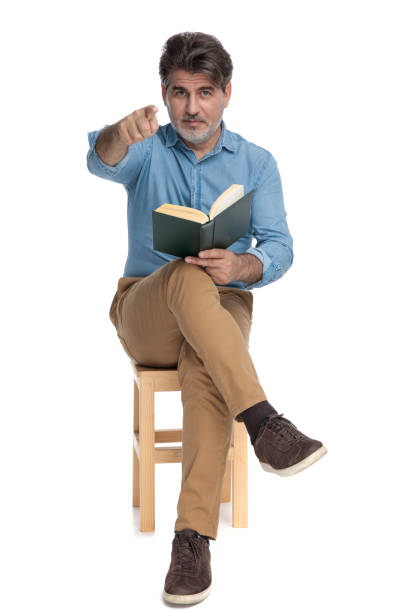 istock Confident casual man reading a book and pointing forward 1202257218