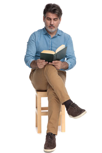 istock Calm casual man reading a book while sitting 1202257243
