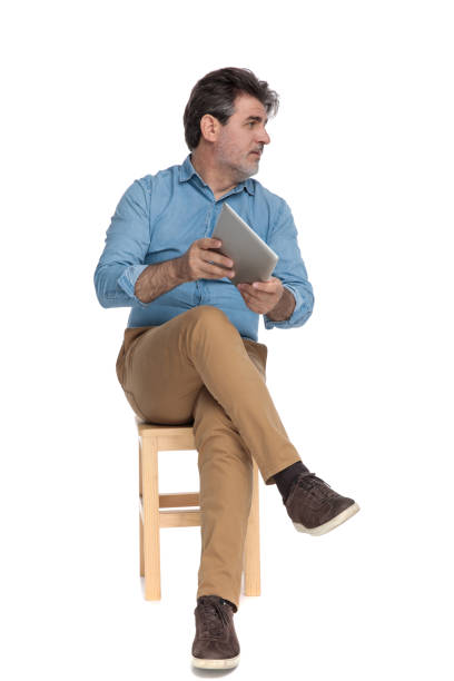istock Serious casual man presenting his tablet to the side 1202257279