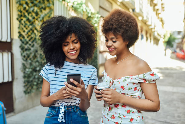istock Friends drinking coffee and using a smartphone on the street 1202257464