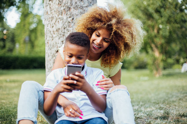 istock Boy playing video games and enjoying with his mom in the park 1202257584