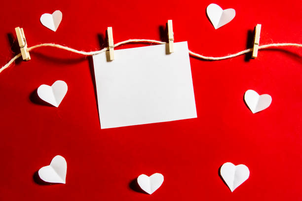 istock Composition for Valentine's Day.  Clothespins, hearts and paper for note against a red background. Elements to use in design or card. 1202257817