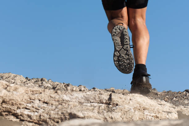 istock Athlete trail running in the mountains on rocky terrain 1202258645