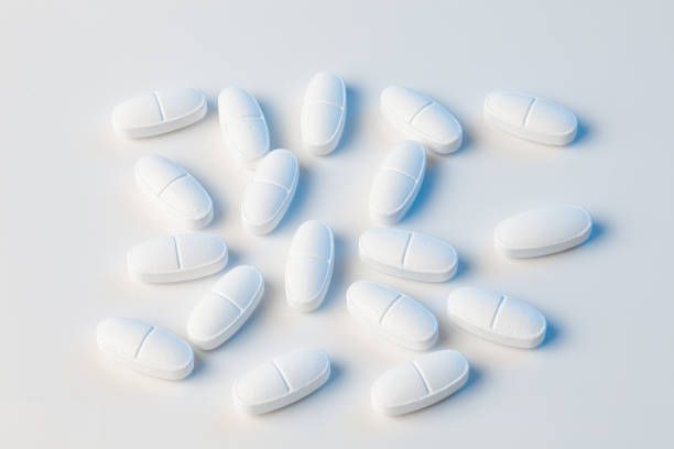 istock white pills on a white background with blue lights 1202259371