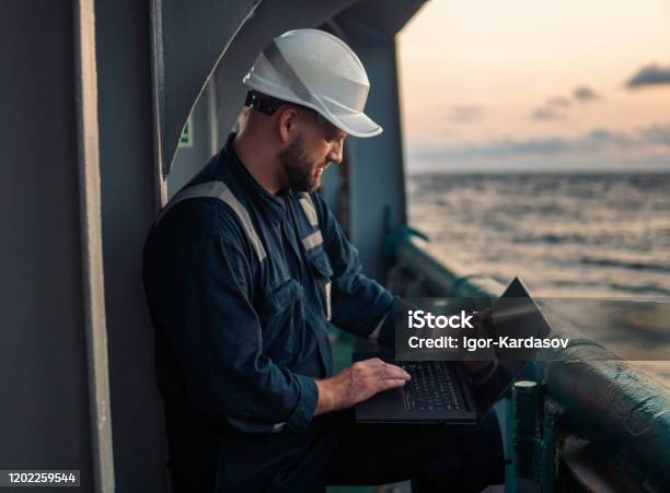 Marine Chief Officer Or Captain On Deck Of Vessel Or Ship Watching Laptop Stock Photo - Download Image Now