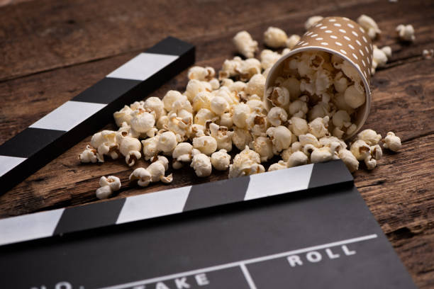 istock Clapper board and popcorn on wooden background 1202260119