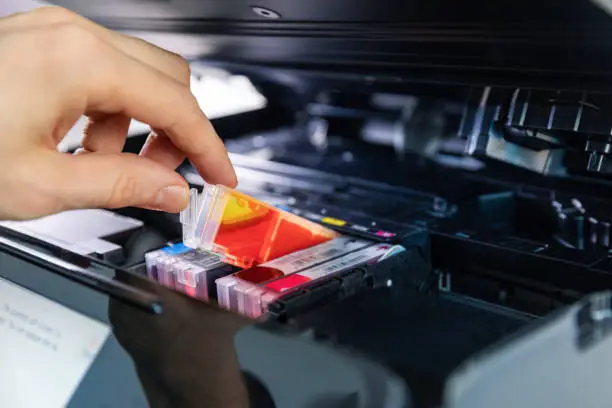 Photo of office equipment maintenance and service - hand replace inkjet printer cartridge