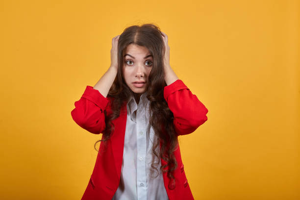 istock Shocked brunette young woman keeping hands on head, having headache, confused 1202261093