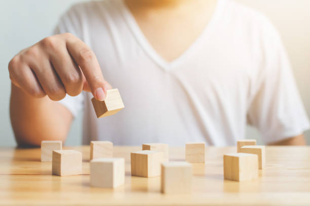 istock Brain therapy rehabilitation cognitive psychological testing. Hand holding wood block cube therapy equipment 1202262637