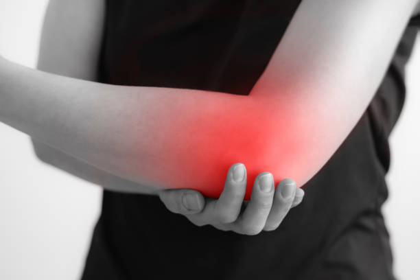 kobieta trzymająca się za ręce. ból w łokciu. palenisko jest podświetlone na czerwono. z bliska. odizolowane tło - pain elbow physical therapy inflammation zdjęcia i obrazy z banku zdjęć