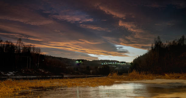 Sunset over the frozen river Nitelva in Norway, winter