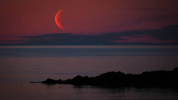 istock Red moon above the ocean 1202265230