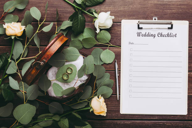 istock Wedding rings and paper planning checklist on wooden table 1202266060