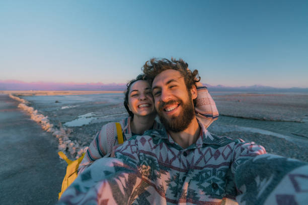 Selfie of woman and man near the  lake in Atacama desert Selfie of young Caucasian woman and man near the  lake in Atacama desert, CHile salar de atacama stock pictures, royalty-free photos & images