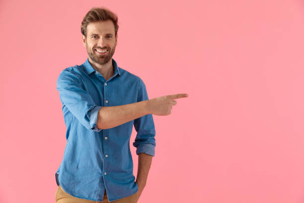 happy young man smiling and pointing finger to side