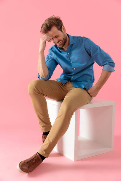 istock happy young casual man looking down and laughing 1202266411