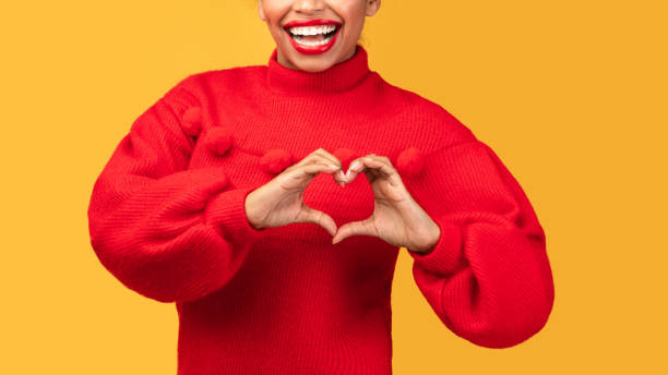istock Afro woman showing heart gesture at studio 1202266802