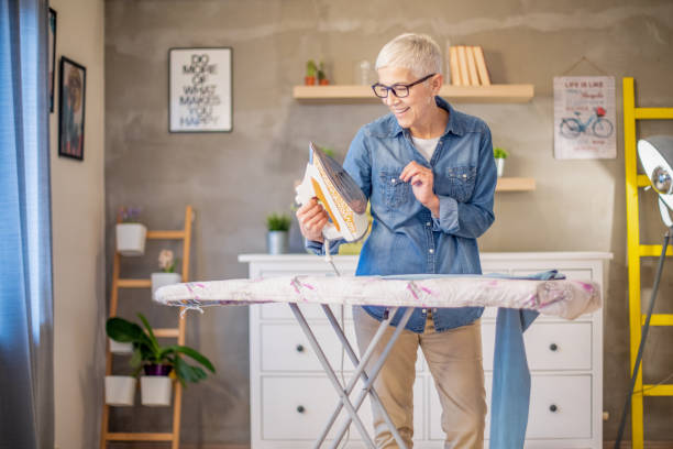 istock Beautiful senior woman ironing her clothes. 1202268291