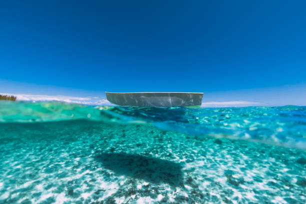 istock Tropical turquoise ocean water with sandy bottom underwater and white boat 1202268379