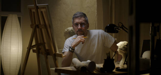 istock Artist sits down to his desk 1202269648