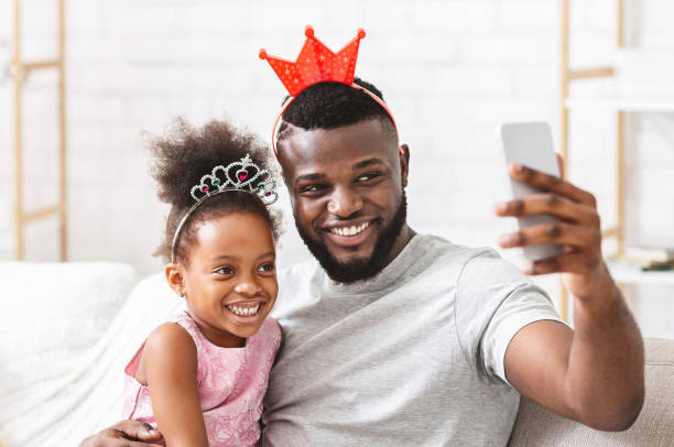 istock Joyful afro family having fun at home, taking selfie 1202271489