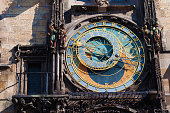 Closeup of astronomical dial of Prague Orloj with intricate details, clockwork, gears, symbols, statues, skeleton and horoscope signs. Prague, Chezh Republic