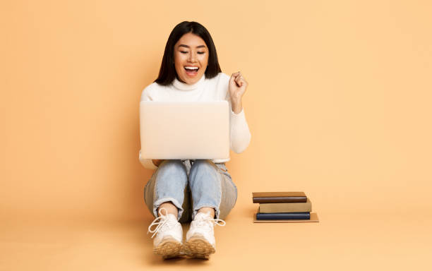 istock Successful student girl celebrating finished project, light background 1202273017