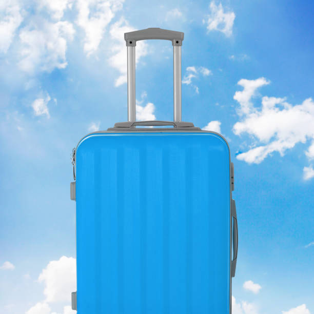 istock Blue luggage with sky background 1202274116