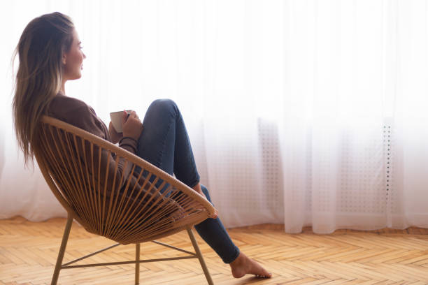 istock Calm woman with coffee enjoying moment, looking at window 1202274220