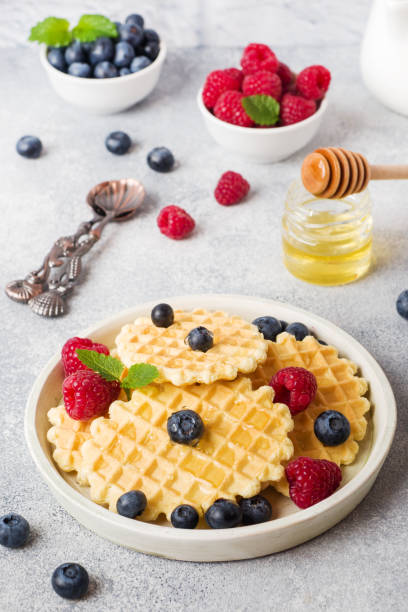 istock Corrugated waffle cookies with fresh raspberries and blueberries on a concrete background. Copy space. 1202274798