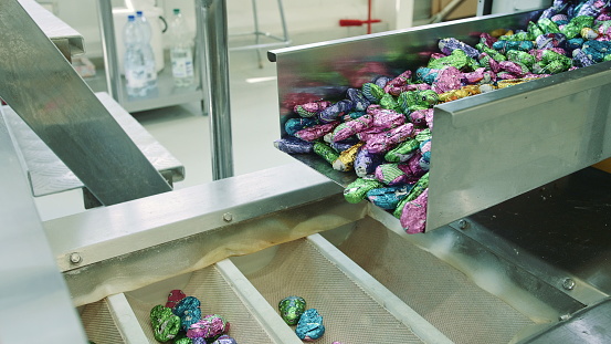 Close-up on a variety of cakes in portions at an industrial bakery - food processing plant concepts