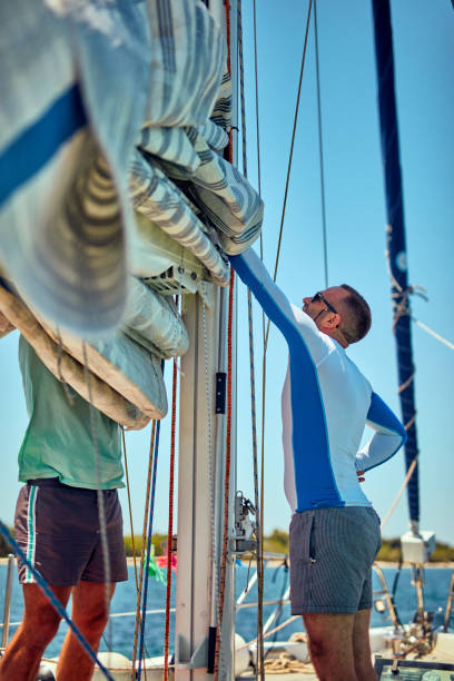 istock Sailor packing / unpacking main sail wing on the boat. 1202276979