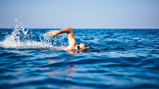 Swimmer training on the open sea / ocean.