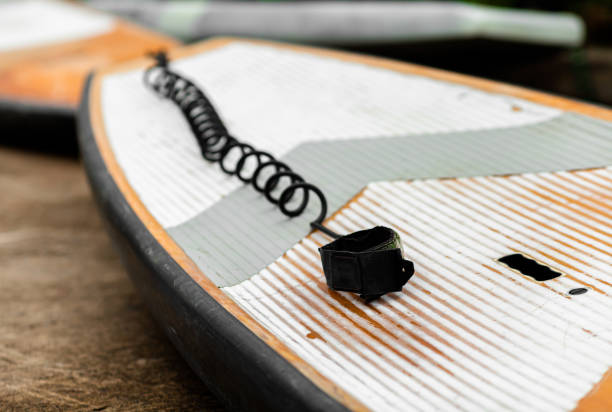 SUP / Stand up Paddle Board Get ready . Surfboard and paddle with Ankle Leash Rope Coiled Stand Up Paddle Board Surfing Cord String on a river lake water . Water sport, happy active summer vacation