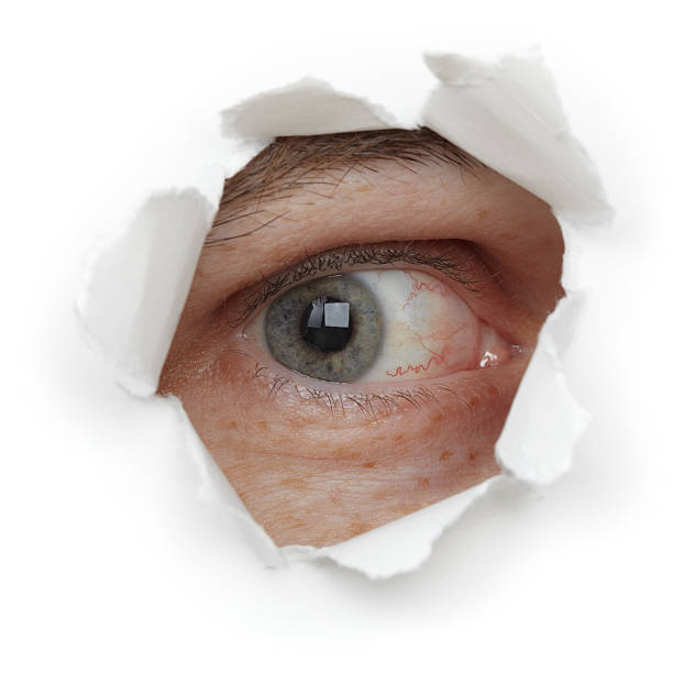 глаз человека в отверстие, крупный план - eye hole стоковые фото и изображения