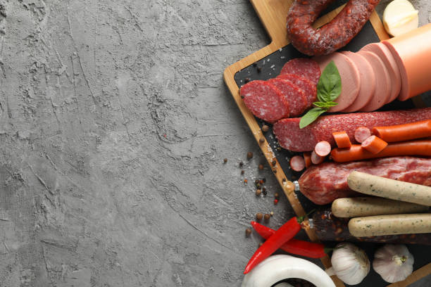 istock Cutting board with sausage and spices on grey background, space for text 1202282816