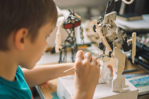 istock Little boy painting a robot skeleton. 1202283223