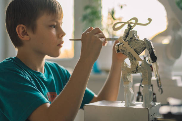 istock Little boy painting a robot skeleton. 1202283306