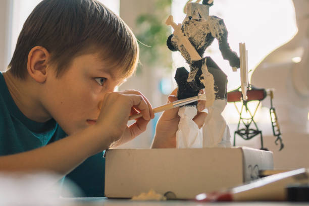 istock Little boy painting a robot skeleton. 1202283398