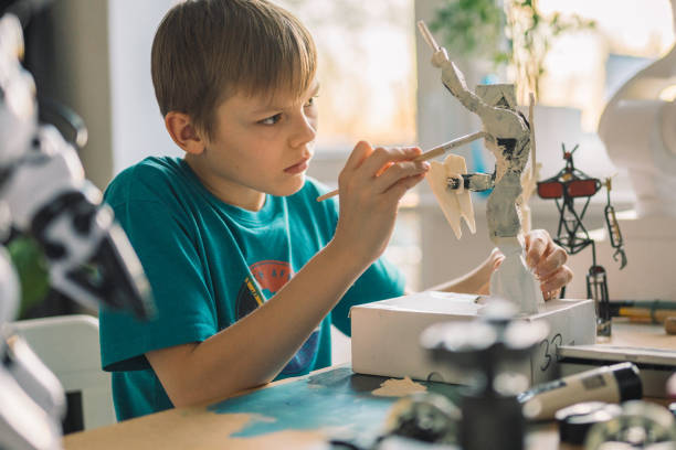 istock Little boy painting a robot skeleton. 1202283431