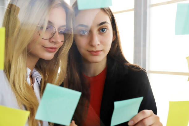 istock Two businesswomen looking at sticky notes 1202283528