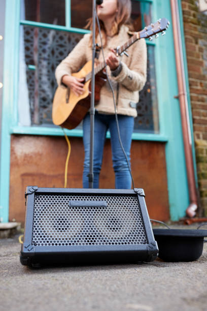 ストリートでアコースティックギターを演奏する女性ミュージシャンバスキングのクローズアップ - street musician ストックフォトと画像