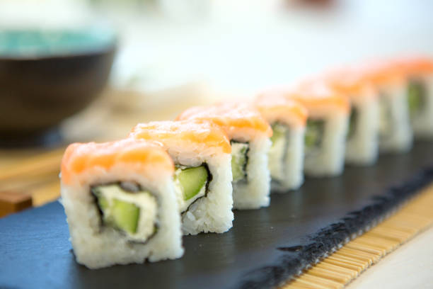 istock salmon sushi rolls on black slate surface. Japanese food 1202284527