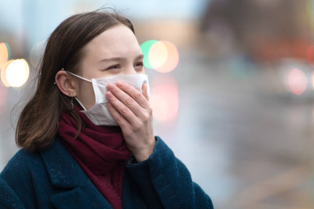 молодая девушка в защитной маске для лица - pollution street city street fog стоковые фото и изображения