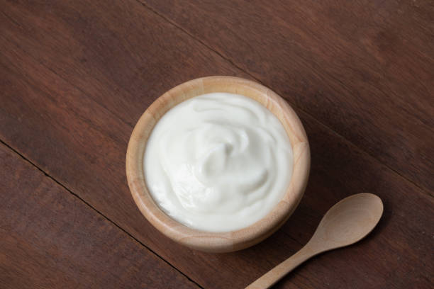 istock Yogurt in wooden bowl on rusty wood table 1202284756