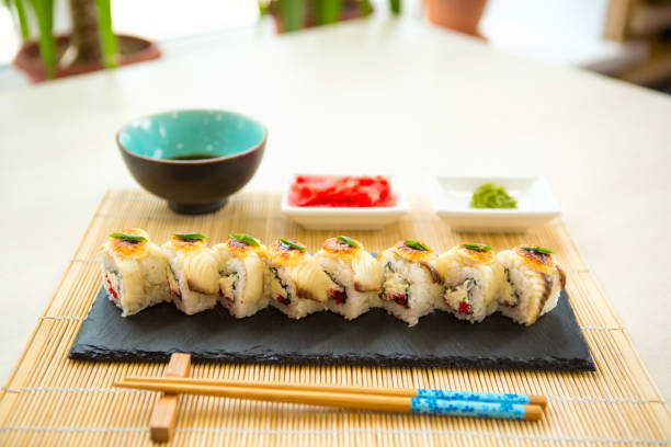 istock Sushi rolls on black slate surface. Japanese food 1202285489