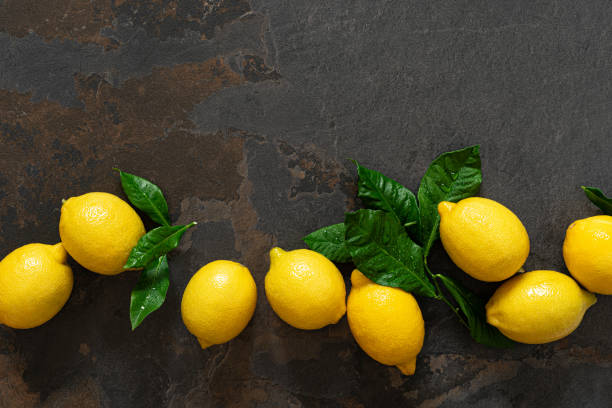 istock Fresh lemons with leaves, vitamin c concept, top view 1202289984